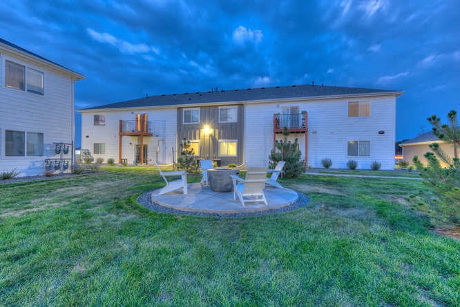 a backyard with a fire pit and a house in the background