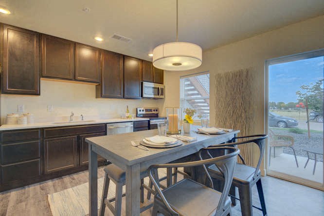 a kitchen with a table and chairs in front of a sliding glass door