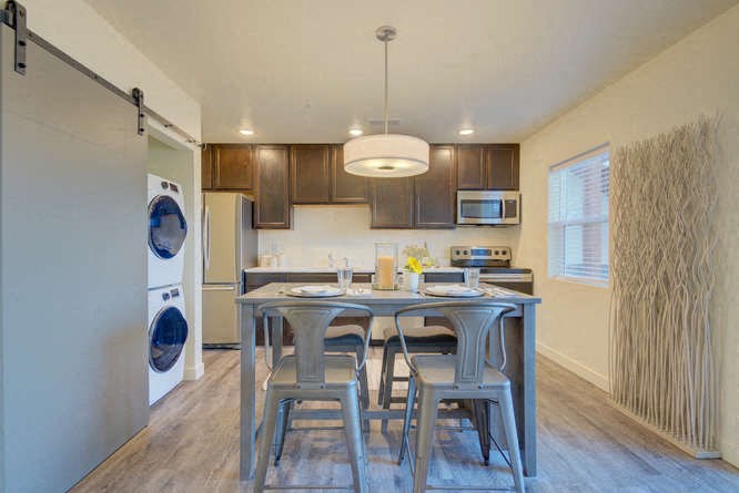 a kitchen with a table and chairs and a washer and dryer