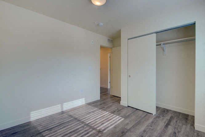 a bedroom with a closet and a door to a bathroom