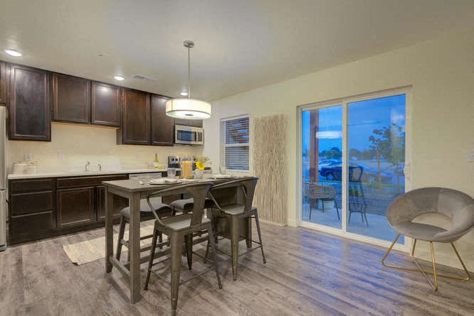 a kitchen with a breakfast bar and a sliding glass door leading to a patio