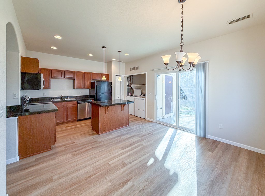 A kitchen with wooden cabinets and a black countertop.