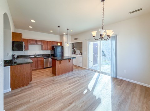 A kitchen with wooden cabinets and a black countertop.