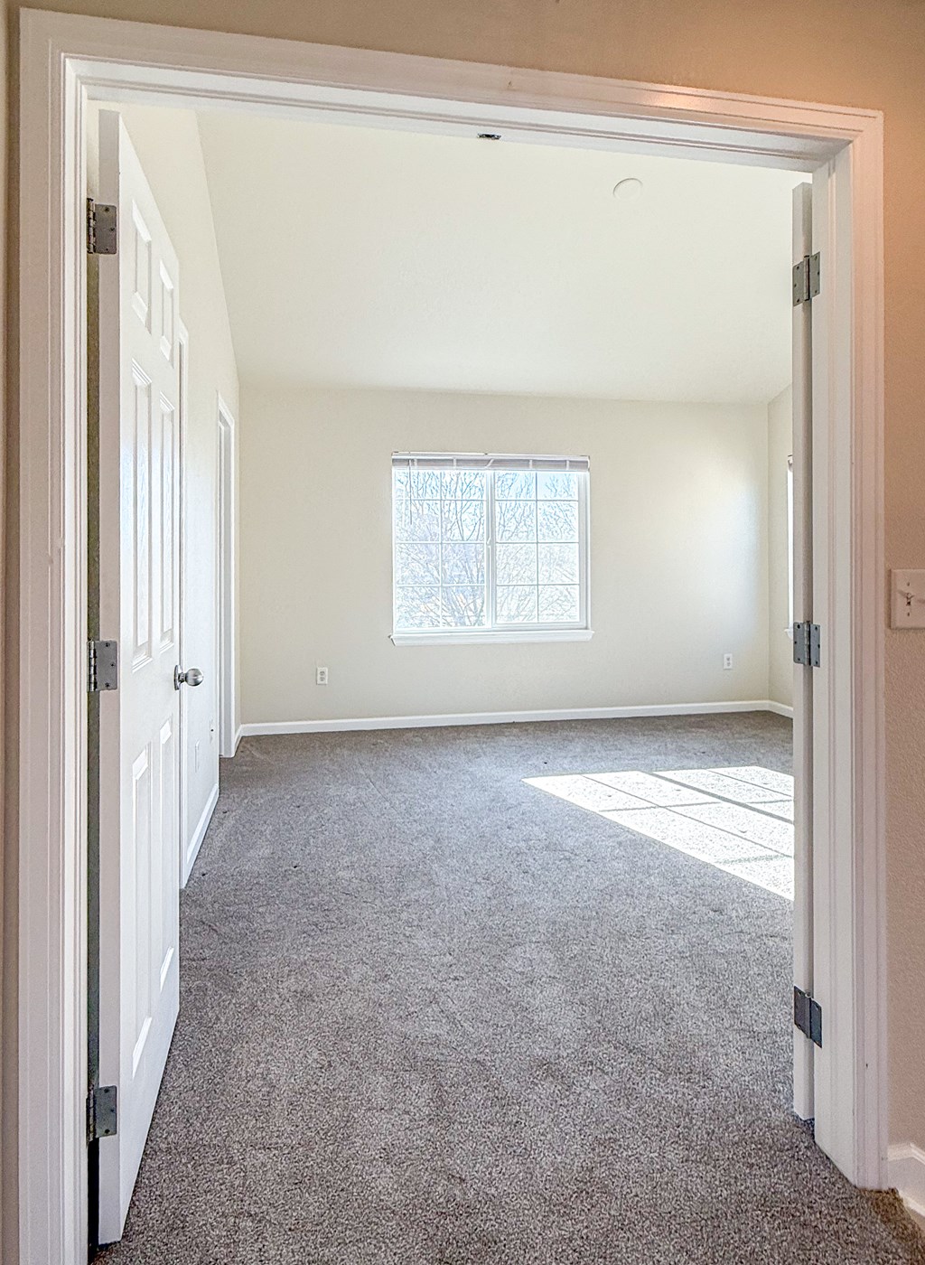 A room with a carpet floor and a window.