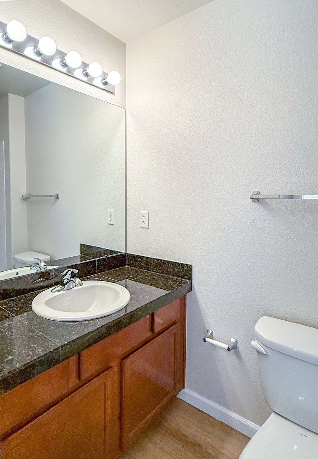 A bathroom with a sink, mirror, and toilet.