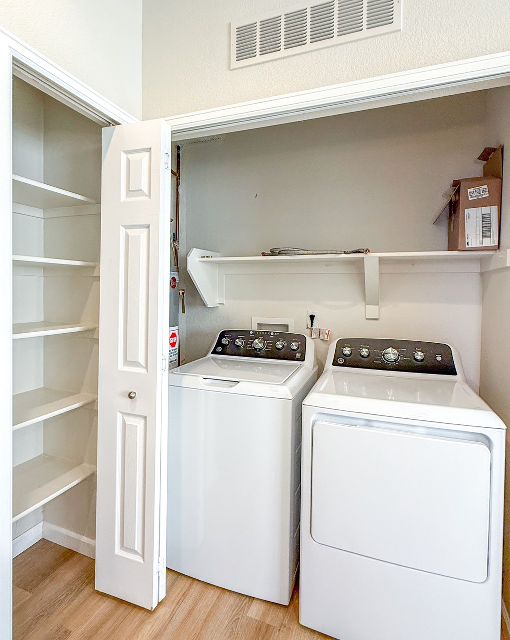 A white dryer and washer in a small laundry room.