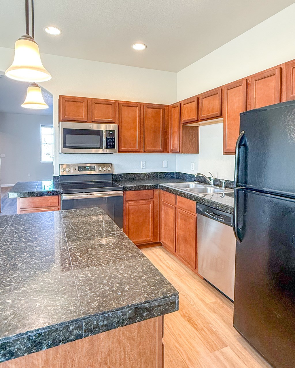 A kitchen with black appliances and wooden cabinets.
