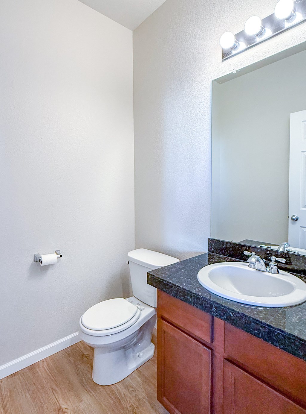 A white toilet sits next to a sink in a bathroom.