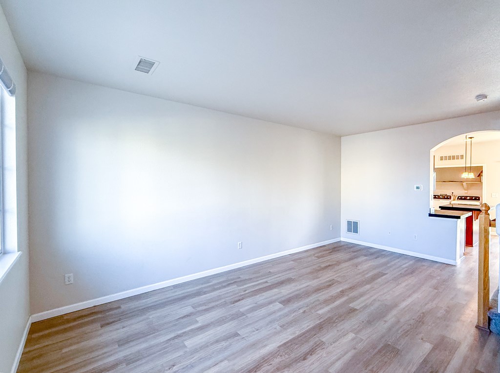 A room with wooden flooring and white walls.