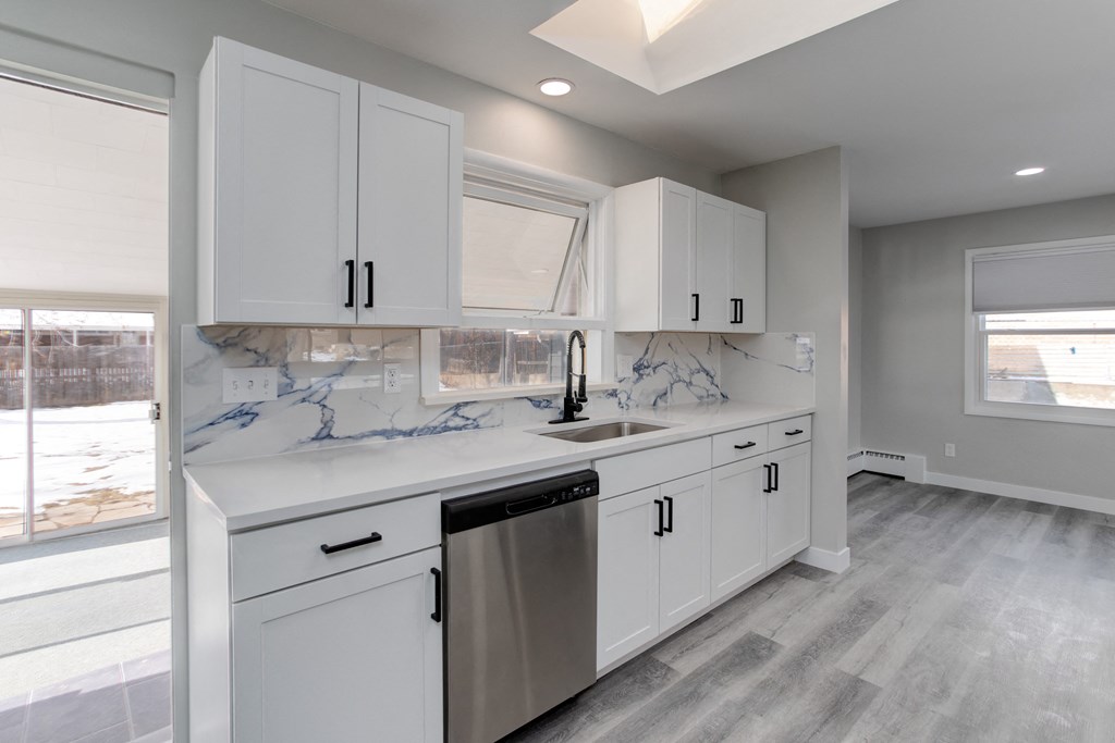 a white kitchen with white cabinets and a stainless steel dishwasher