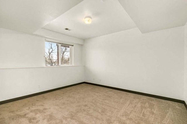 an empty room with a window and a carpet