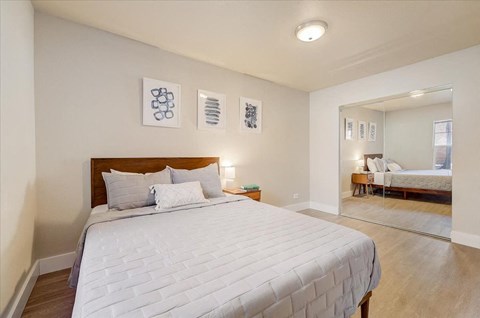 a bedroom with a large bed and a mirror