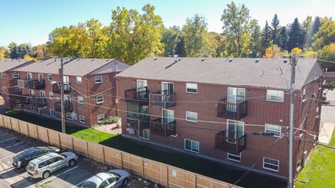 Apartment building with cars parked in front.
