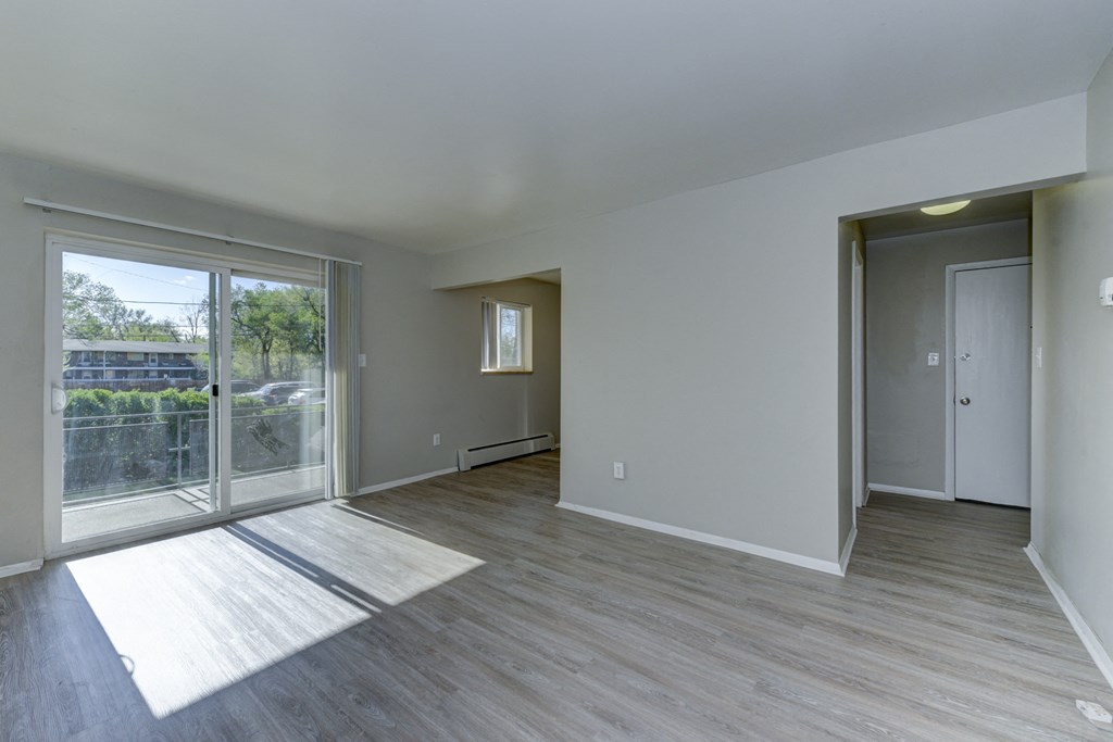 an empty living room with sliding glass doors to a balcony
