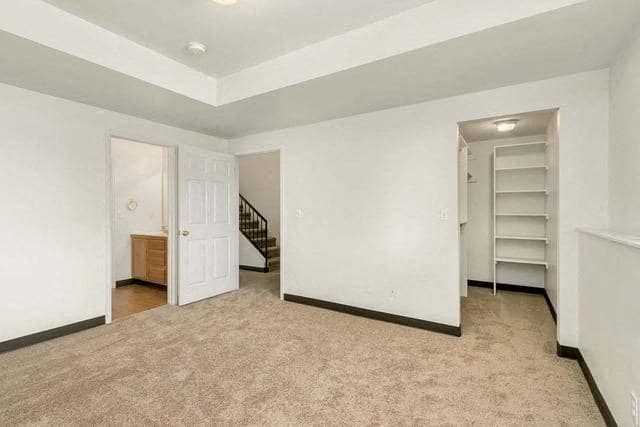 an empty living room with a staircase and a closet