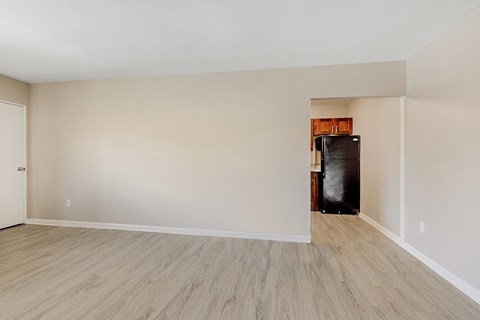 A room with a white door and a black refrigerator.