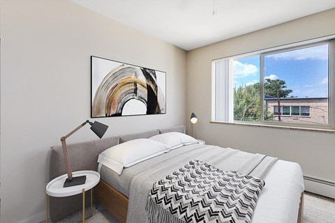 A bedroom with a large bed and a painting on the wall.