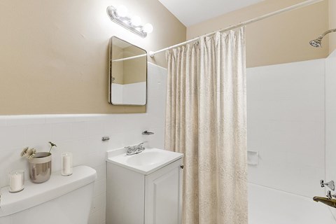 A white sink sits under a mirror in a bathroom.