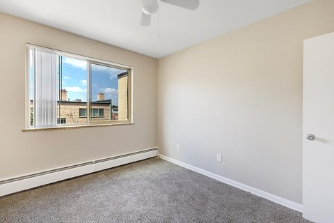A room with a window showing a view of a building outside.