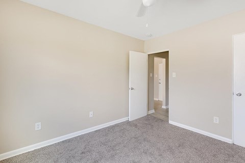 A room with a carpeted floor and a white door.