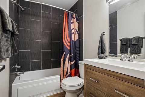 A bathroom with a white toilet, a white sink, and a shower curtain.