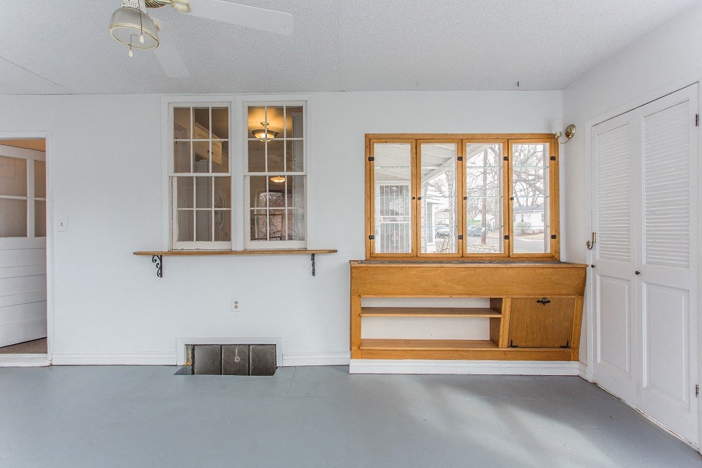 a living room with a large window and a wooden bench