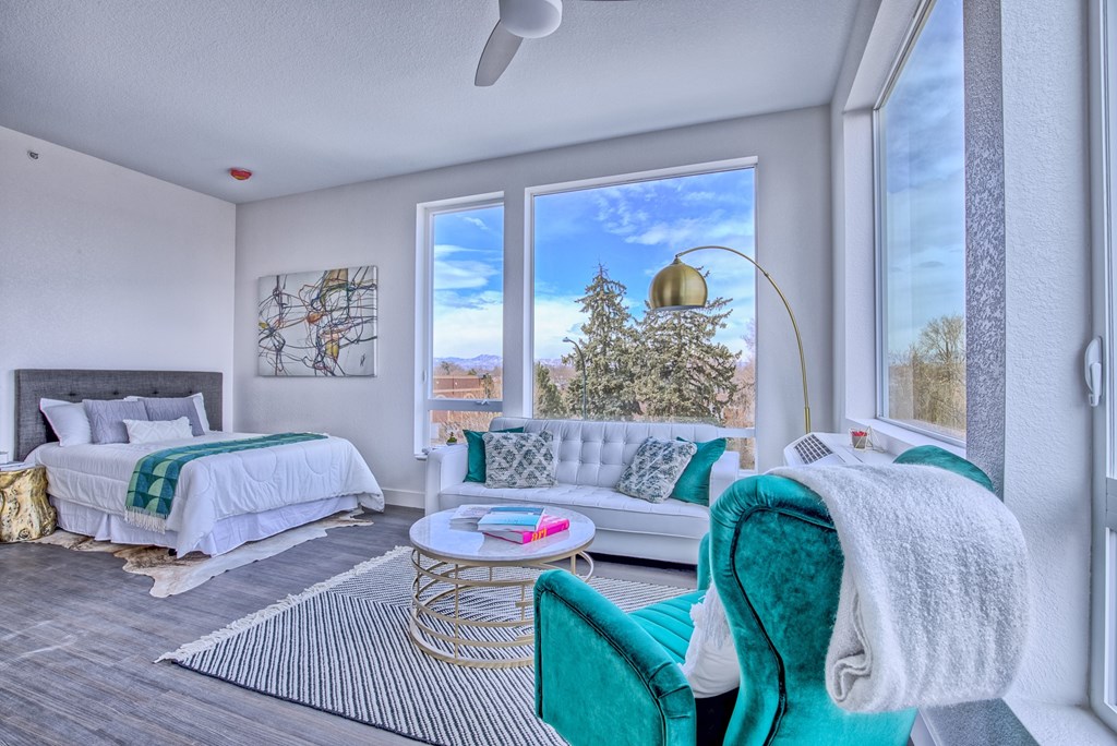 A room with a bed, a chair, and a table.