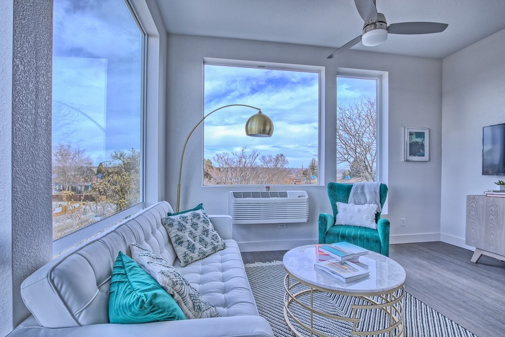 A living room with a white couch and a gold coffee table.