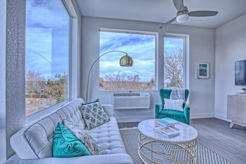 A living room with a white couch and a gold coffee table.