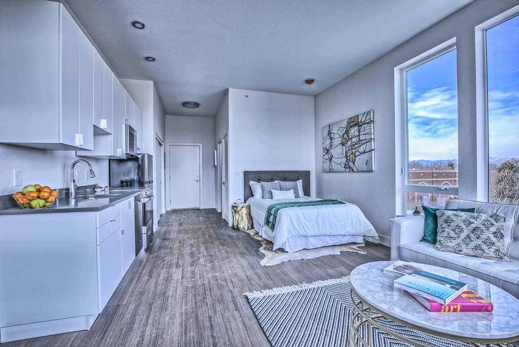 A modern kitchen with a dining area and a bedroom.