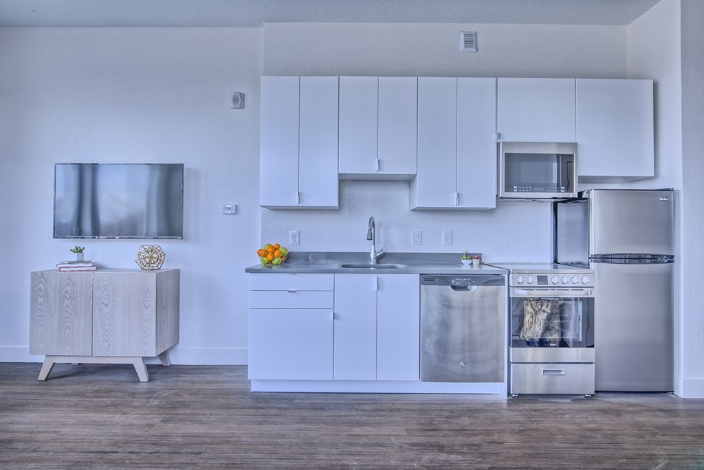 A modern kitchen with stainless steel appliances and white cabinets.