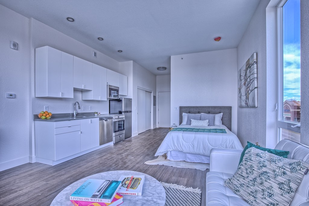 A well-lit, modern kitchen and living room with a view of the sky.