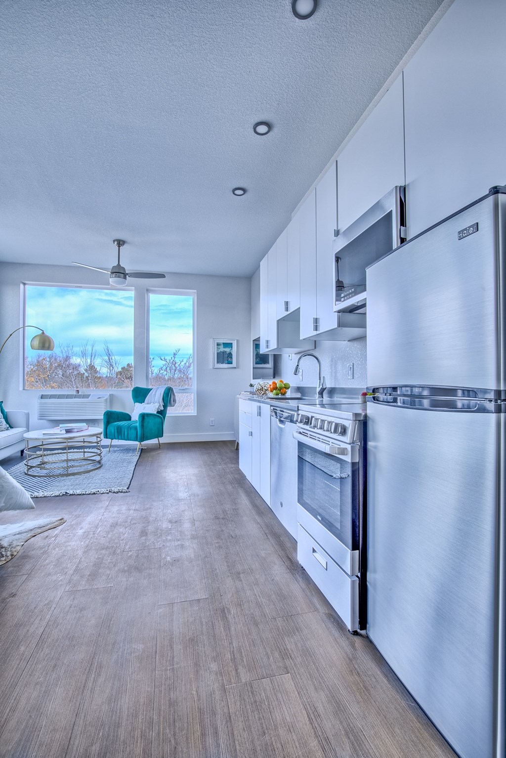 A modern kitchen with a refrigerator, oven, and microwave.