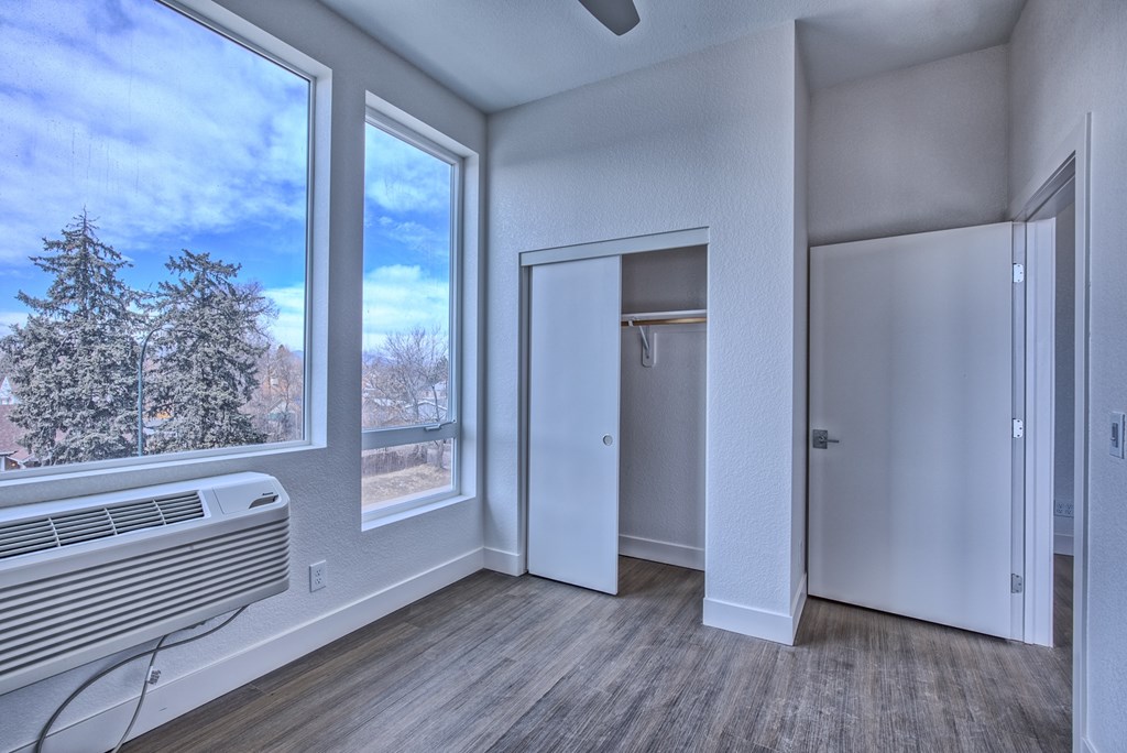 A room with a window, a door, and a wall heater.