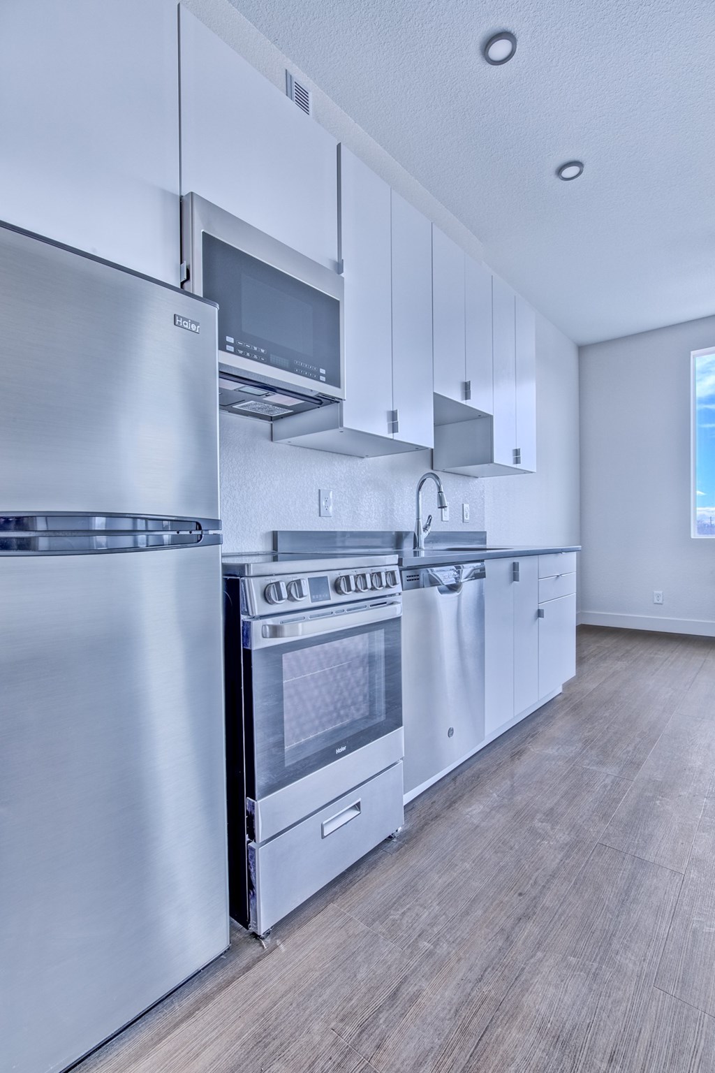 A modern kitchen with stainless steel appliances and white cabinets.