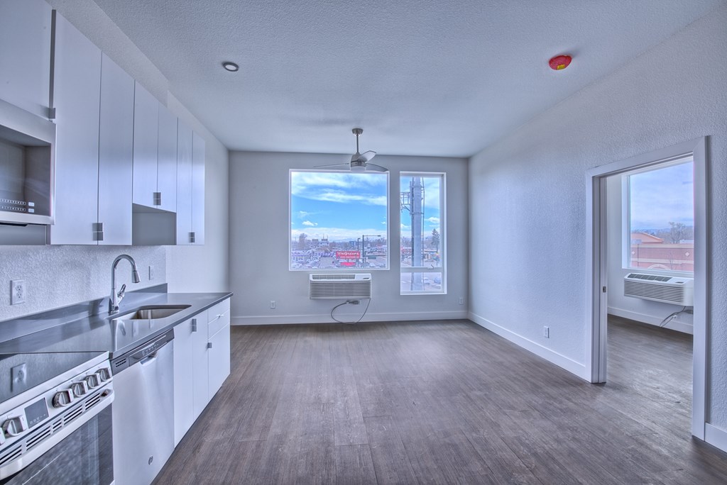 A kitchen with white cabinets and a stainless steel sink.