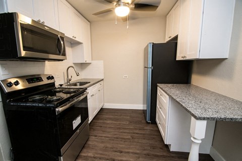 a kitchen with black appliances and white cabinets