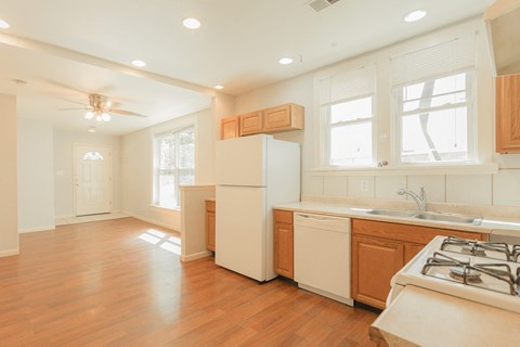 A kitchen with a white refrigerator, wooden cabinets, and a stove top oven.