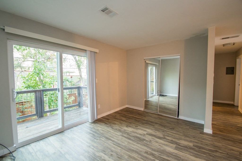 an empty living room with sliding glass doors to a balcony