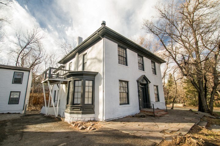 a white house with black windows and a sidewalk
