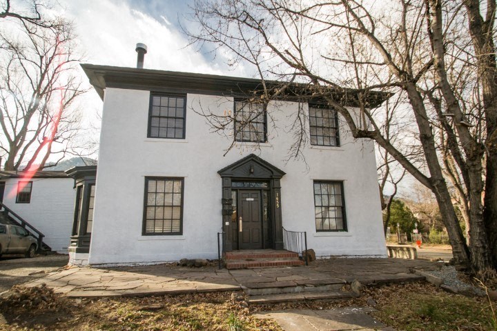 a white house with a tree in front of it
