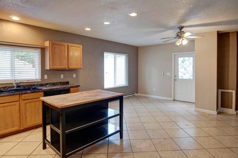A kitchen with a black counter top and wooden cabinets.