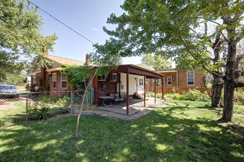 A house with a red brick exterior and a green lawn.