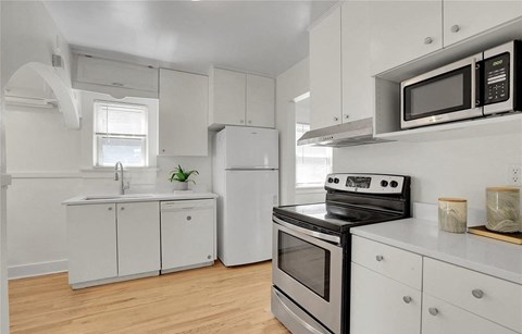 a kitchen with white cabinets and a stove and a microwave
