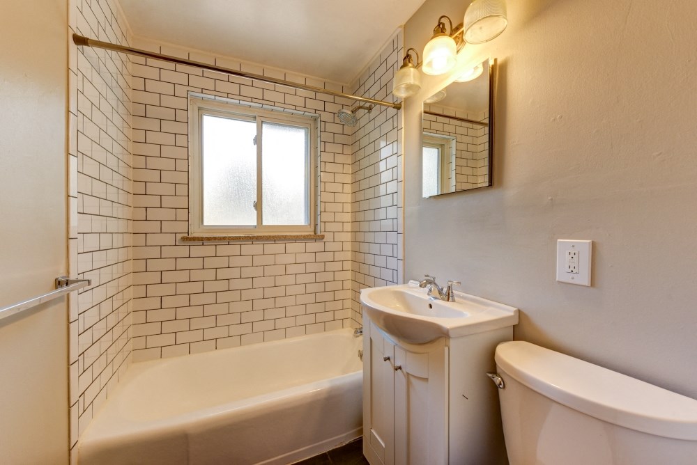 a bathroom with a sink toilet and tub and a window