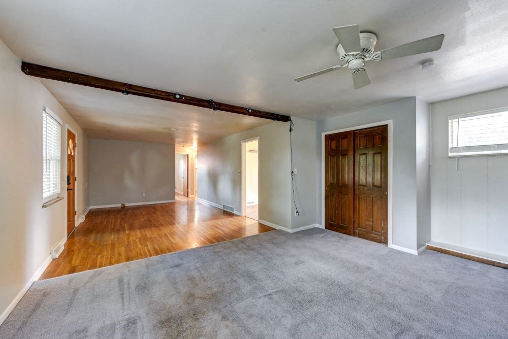 an empty living room with a ceiling fan