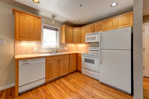 A kitchen with wooden cabinets and white appliances.