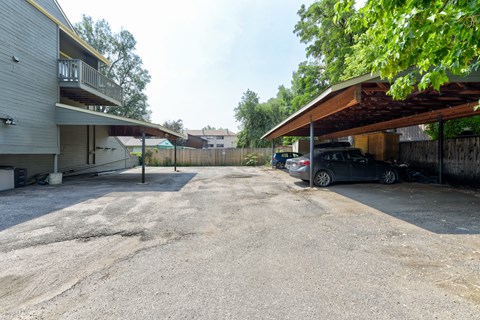 A parking lot with a car parked and a building on the left.