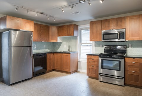 A kitchen with a refrigerator, oven, and microwave.
