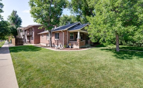 a brick house with a yard and trees